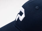 pureest keps. Broderad logo i vitt & mörkblå tyg