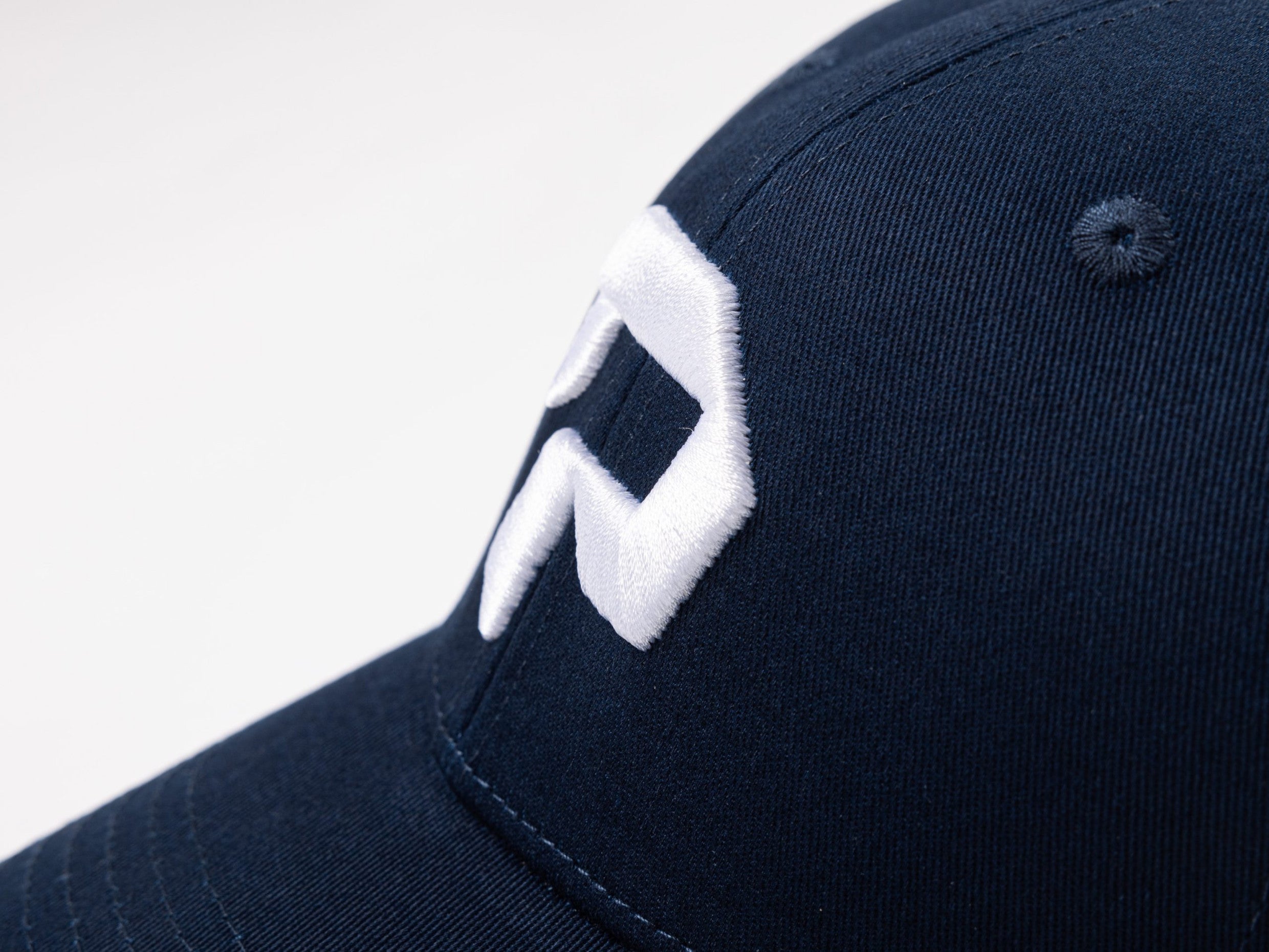 pureest keps. Broderad logo i vitt & mörkblå tyg